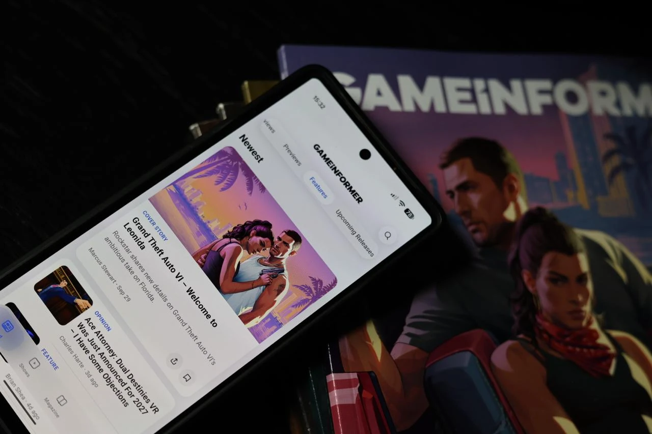 Game Informer app on a phone beside GTA VI magazine covers