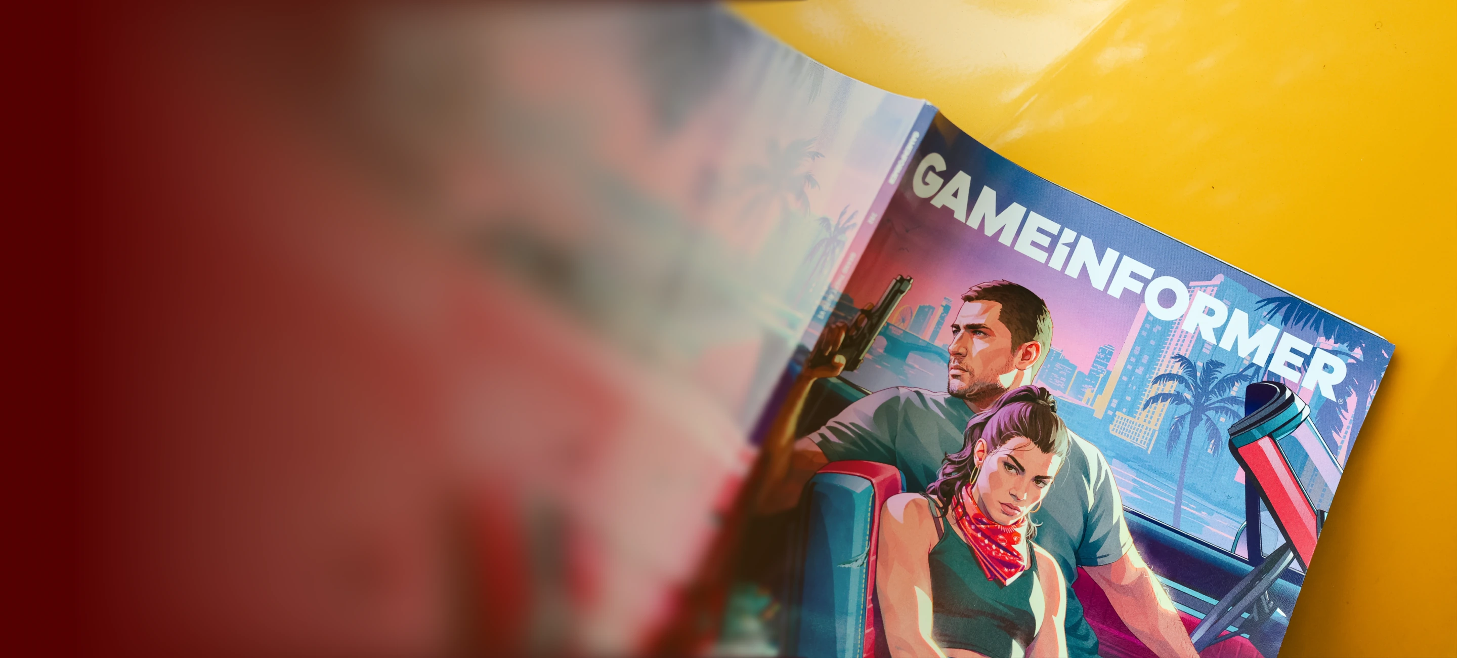 Game Informer GTA VI magazine photographed on a bright yellow table